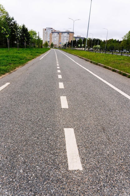 An empty city bike path along a city street in summer