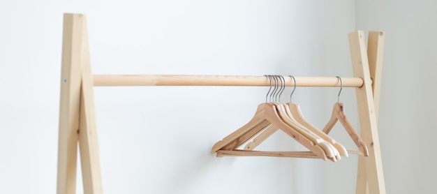 empty clothes hangers hanging on a clothes rack in the bedroom. copy spase