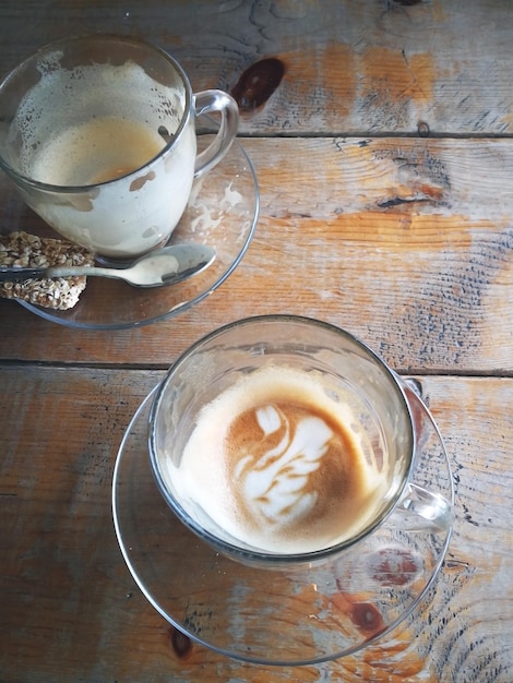 Empty coffee cup with cookies on wooden table in coffeehouse