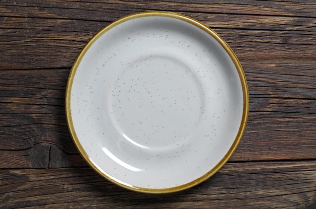 Empty colorful plate on dark wooden background, top view