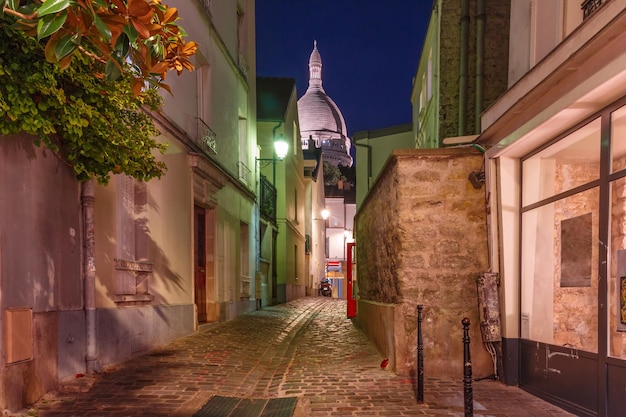 Empty cozy street and the sacrecoeur basilica at night quarter montmartre in paris france