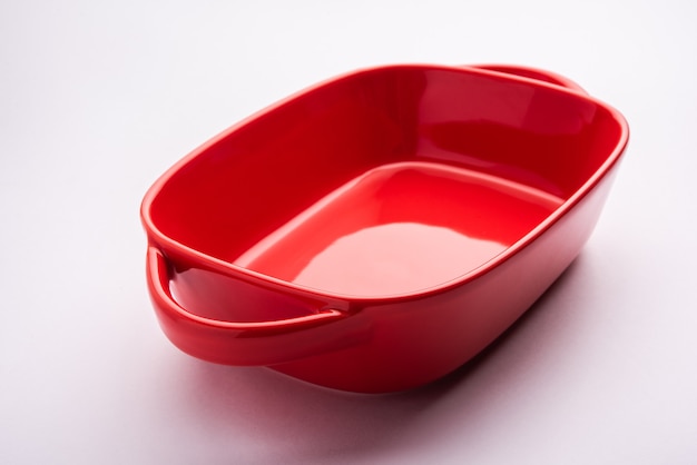 Empty Crockery - red ceramic bowl or bakeware without food on white background