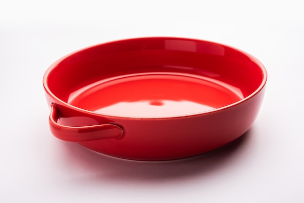 Empty Crockery - red ceramic bowl or bakeware without food on white background