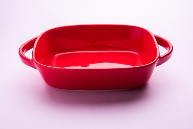 Empty Crockery - red ceramic bowl or bakeware without food on white surface