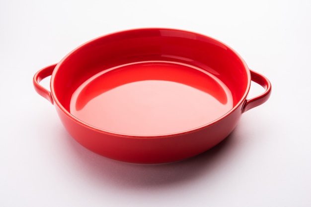 Empty Crockery - red ceramic bowl or bakeware without food on white surface