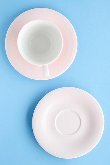 Empty cup and saucer on blue background flatlay