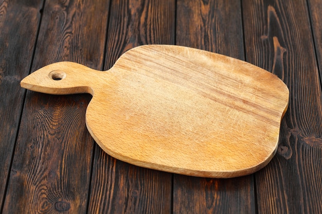 Empty cutting board on a dark wooden table