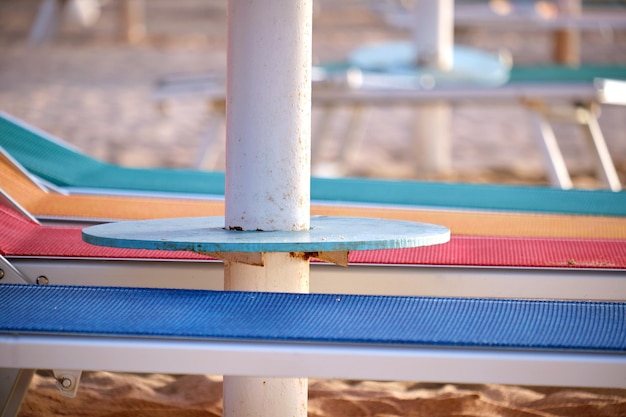 Empty deck chairs on sandy beach sea side in summer resort Vacations and getaway concept