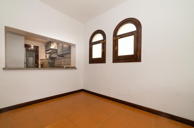 Empty dinning room area in an apartment next to the kitchen and with two windows