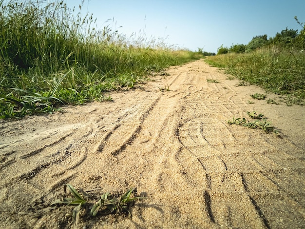 Empty dirt road through the meadow Footprints in the sand