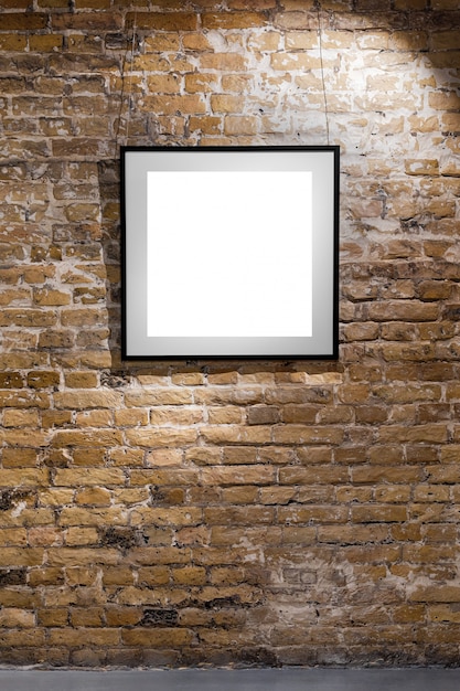 Empty frame on light brick wall. Blank space poster or art frame waiting to be filled. Square Black Frame