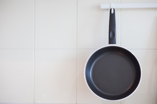 Empty frying pan hanging on the kitchen wall