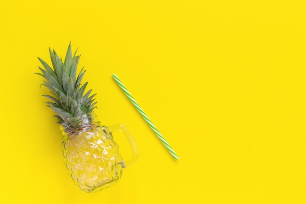 Empty glass jar with green leaves pineapple and straw for fruit or vegetable smoothies