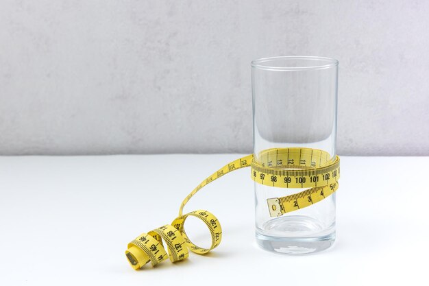 Empty glass wrapped with a centimeter tape with copy space proper nutrition