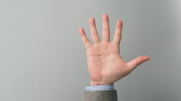 Empty hand palm in businessman grey suit on grey background.