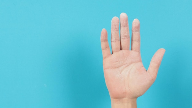 Empty hand palm with baby powder on blue background