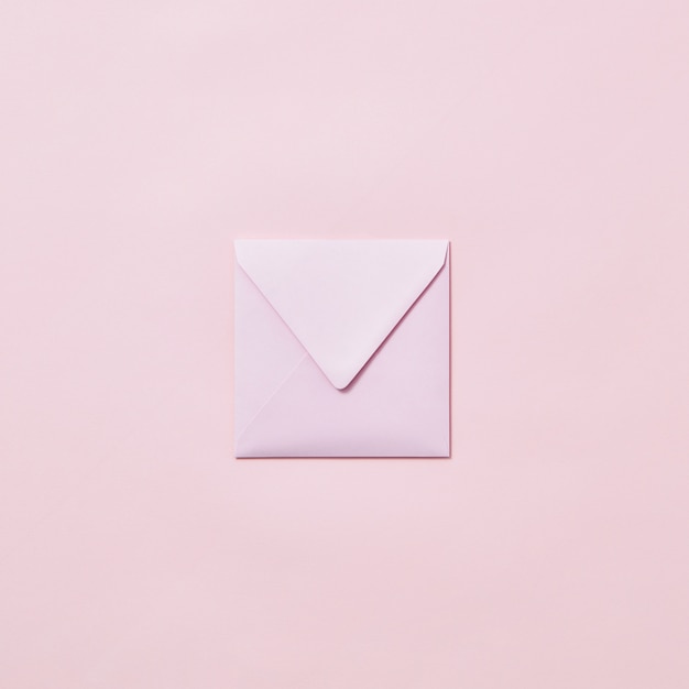 Empty handmade envelope for congratulation card on a light pink background with copy space.