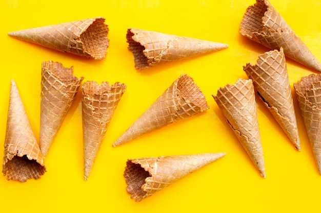 Empty ice cream cone on yellow background