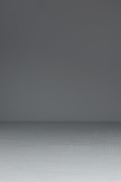 An empty light wooden table on a dark background. Vertical