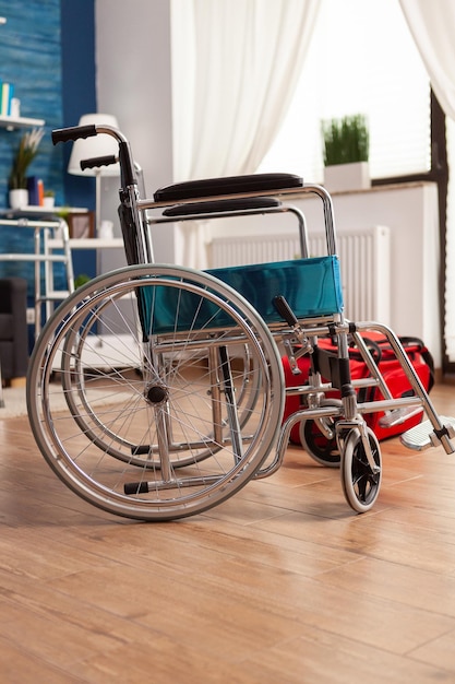 Empty living room with no one in it with medical wheelchair next to red physical therapist rehab bag ready for specialized physical therapy session. Support center for people with disabilities.