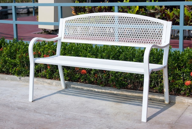 Empty long white metal chair in the park outdoor