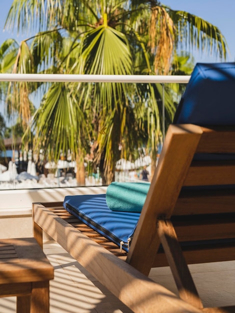 An empty lounge chair and palm trees