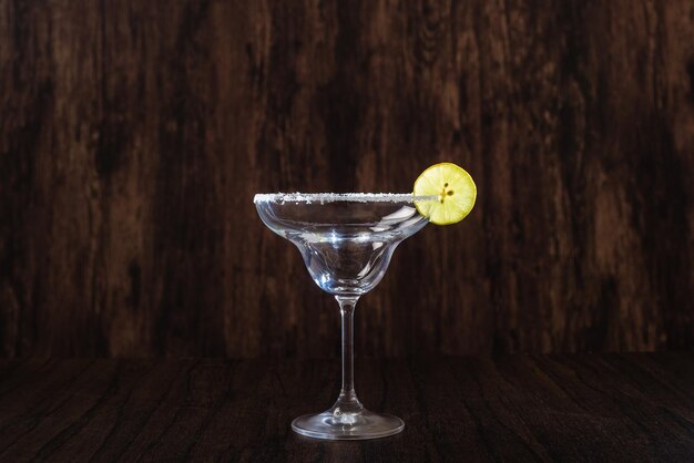 Empty margarita cocktail glass isolated on dark background