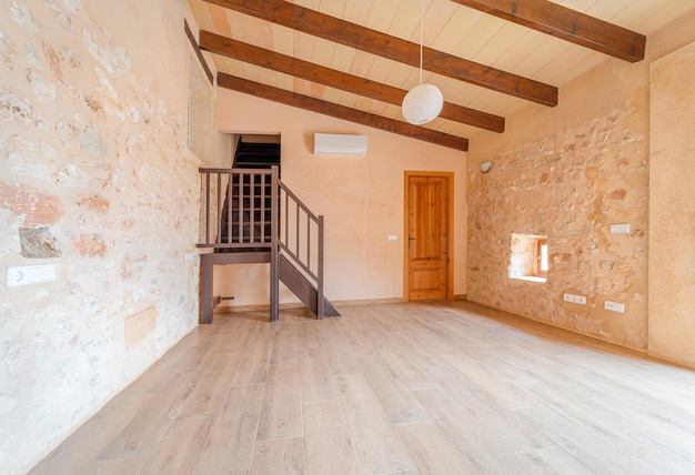 Empty master bedroom with parquet floors wooden beams stairs balcony and air conditioning