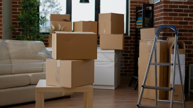 Photo empty new apartment space with furniture packages in boxes, moving in household property. no people in real estate house to move with things in storage cardboard cargo containers.