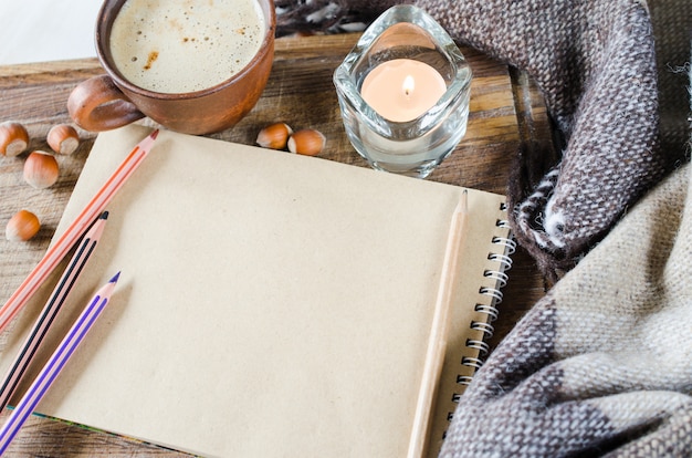 Empty notebook, plaid, candle and coffee cup