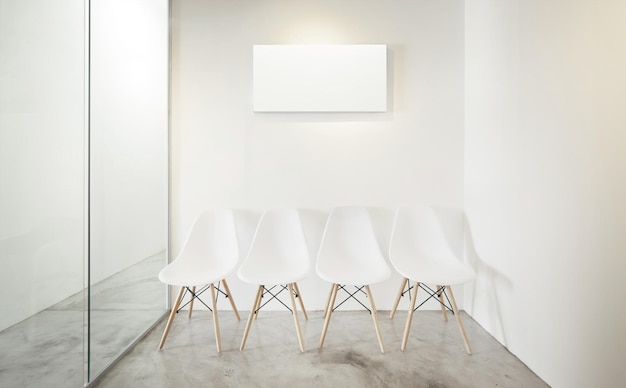 Photo empty office room glass window to the left loft interior style white canvas print on the center white wall four white chairs at the concrete floor