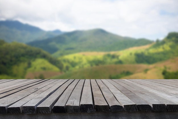 Empty old wooden table in front of blurred beautiful view tree mountain forest cloud blue sky on clear day in autumn Can be used for display or montage for show your product