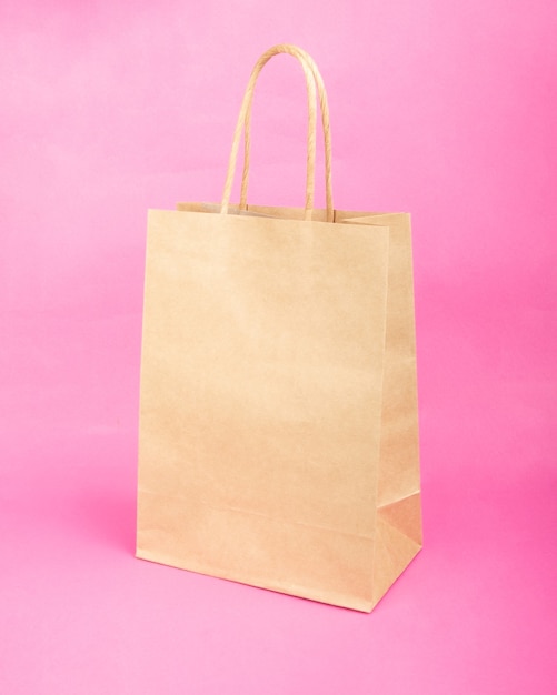 Empty paper bag with copy space for lettering sale mockup on pink background