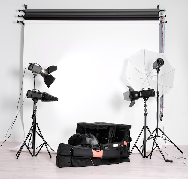 Empty photo studio with lighting equipment bags and backdrop