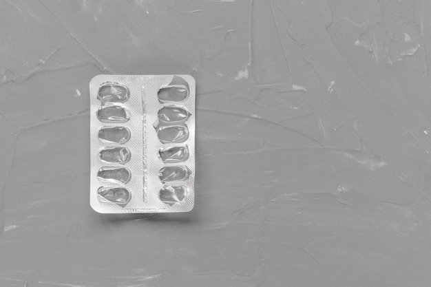 Empty pill blister on gray background supplement concept