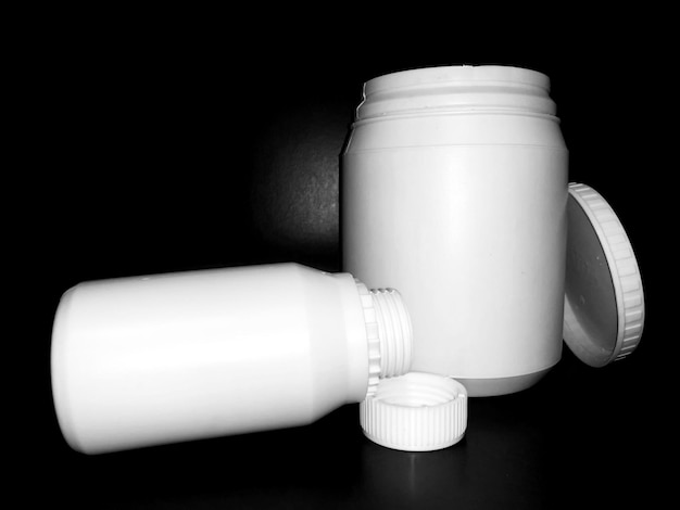 Empty plastic white bottles on a dark background.