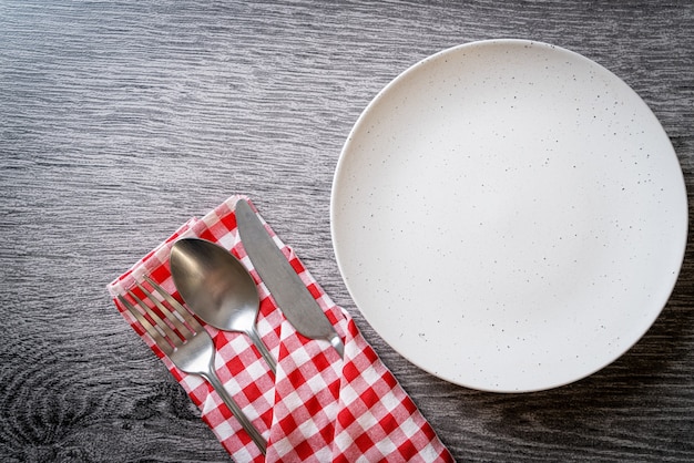 empty plate or dish with knife, fork and spoon on wood table