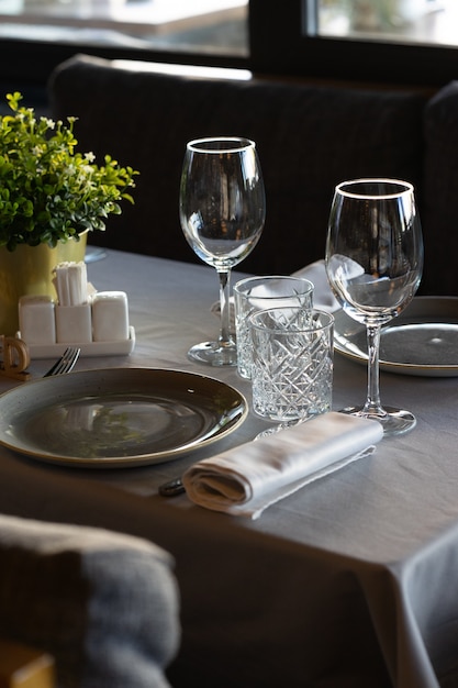 An empty plate, glass and glass and on a cafe or restaurant table set for two guests