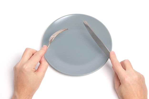 Empty plate and hands with cutlery spoon and fork white background.