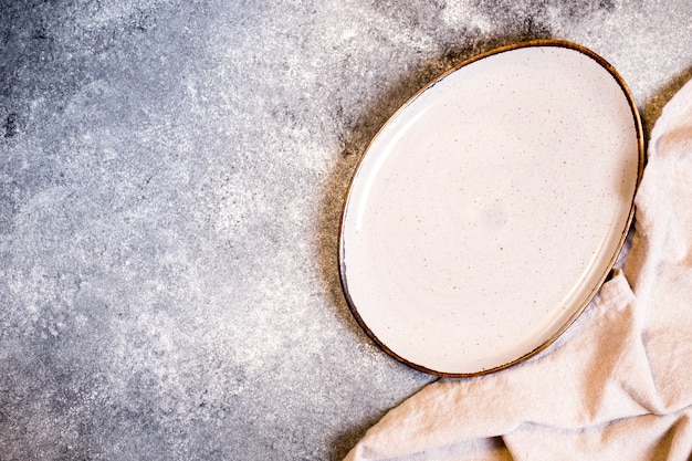 empty plate and napkin on a grey table