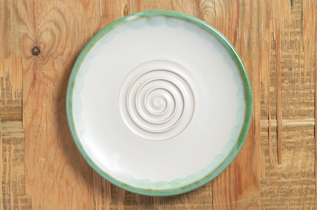 Empty plate on old wooden background, top view