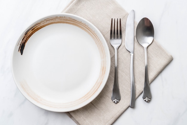 empty plate spoon fork and knife