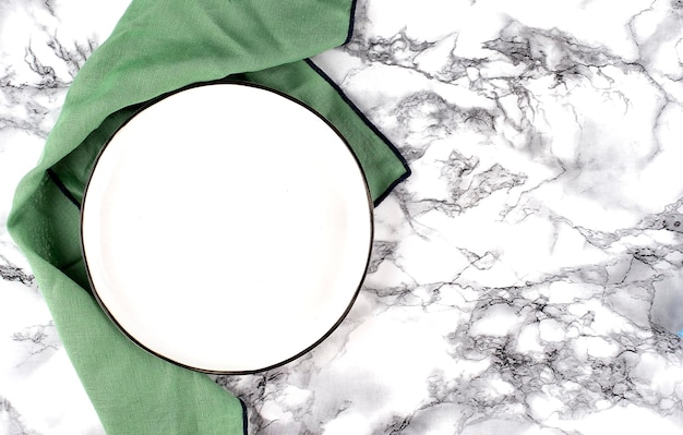 Empty plate and towel over marble table Top view with copy space