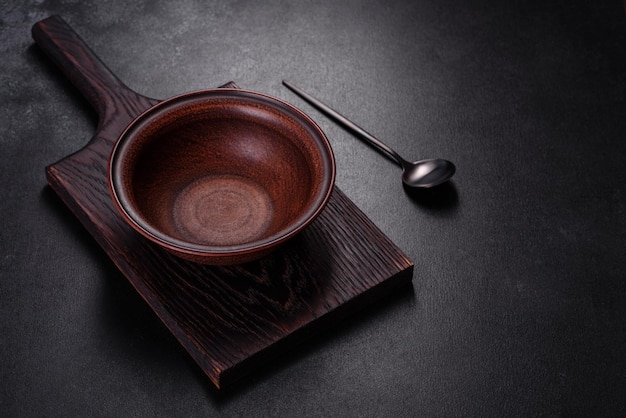 An empty plate with a knife fork or spoon with a wooden cutting board