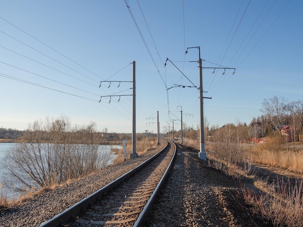 Empty railway track single rail Railway track turns and twists between out of focus hills background Empty rounding and turning single track of railways