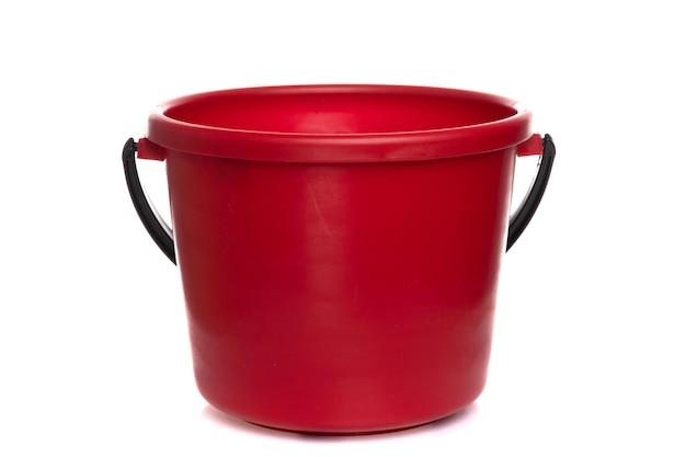 Empty red plastic bucket with black handle on white isolated background