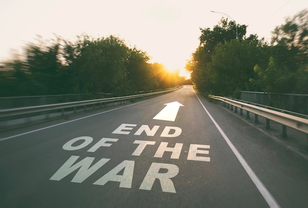 The empty road in the forest and the text on the asphalt The end of the war