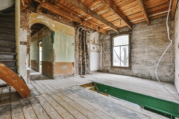 An empty room with wooden floors and brick walls in an old house in need of renovation