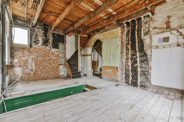 An empty room with wooden floors and brick walls in an old house in need of renovation