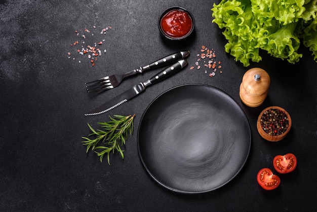 Empty round black plate on dark moody black background with copy space